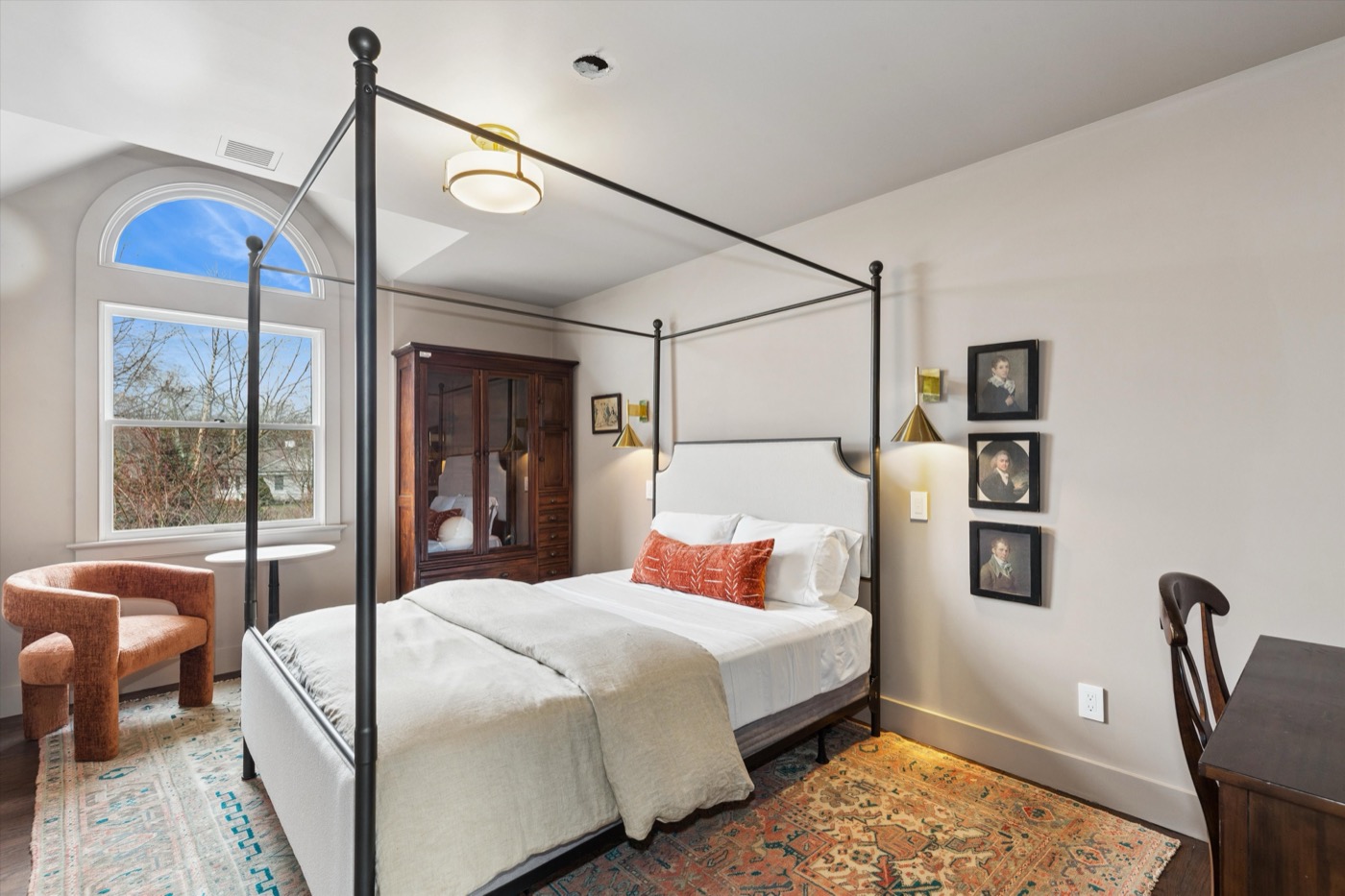 Glynn Gardens bedroom — four-poster iron bed with arched window