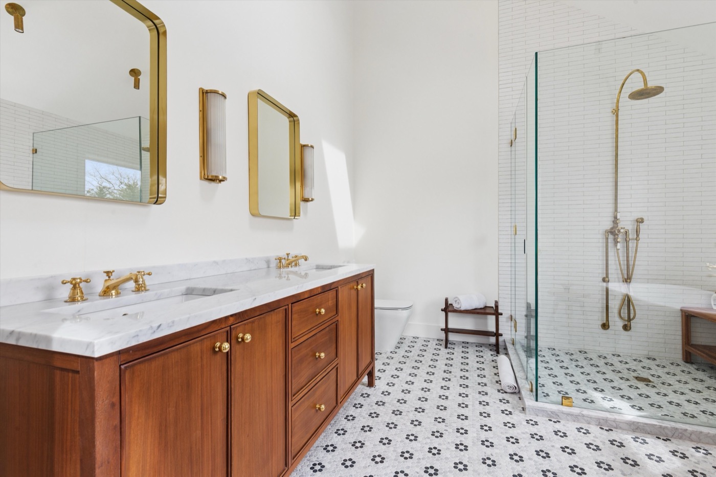 Glynn Gardens primary bath — walnut double vanity with gold mirrors