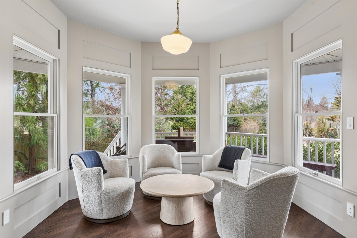 Glynn Gardens sunroom — boucle chairs and garden views
